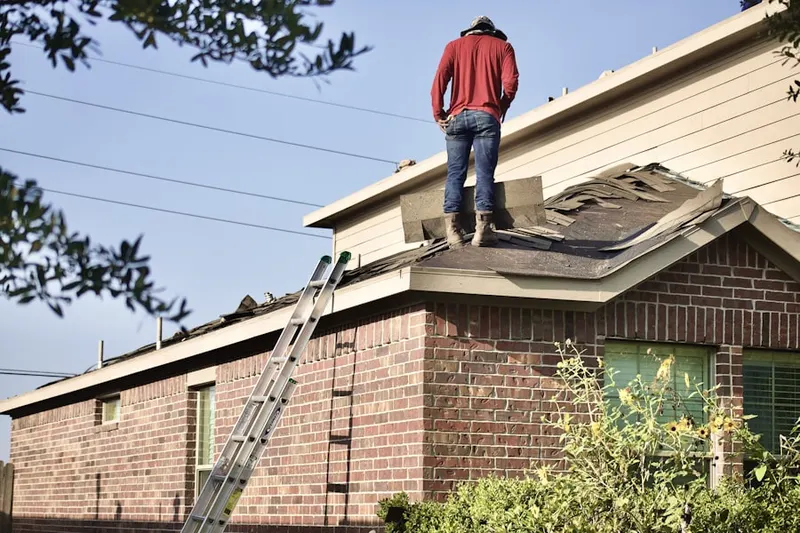 Professional roofer working on a residential roof in Markleton